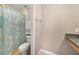 Bright bathroom featuring a tub with themed shower curtain and single granite vanity with a neutral wall color at 1425 Riviera Dr, Kissimmee, FL 34744