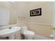Powder room featuring a pedestal sink, tile floor, and neutral paint color with decorative chair rail at 1425 Riviera Dr, Kissimmee, FL 34744