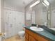 Bright bathroom featuring a tub with floral shower curtain and single vanity with a green countertop at 1425 Riviera Dr, Kissimmee, FL 34744