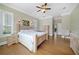 Bright bedroom features hardwood floors, a ceiling fan, and an ensuite bathroom at 1425 Riviera Dr, Kissimmee, FL 34744