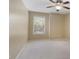 Neutral bedroom with a ceiling fan and bright natural light streaming in through the window at 1425 Riviera Dr, Kissimmee, FL 34744