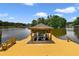 Wooden dock and boathouse featuring a boat lift, bench seating, and lake views at 1425 Riviera Dr, Kissimmee, FL 34744