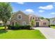 Charming two-story home featuring a well-manicured lawn and beautiful landscaping at 1425 Riviera Dr, Kissimmee, FL 34744