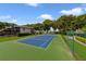 Aerial view of a well-maintained blue and green outdoor tennis court on a sunny day at 1425 Riviera Dr, Kissimmee, FL 34744