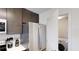 Modern kitchen features stainless steel appliances, dark wood cabinets, and laundry area with a washer and dryer at 14501 Grove Resort Ave # 2440, Winter Garden, FL 34787