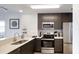 Modern kitchen with stainless steel appliances, quartz countertops and dark cabinets at 14501 Grove Resort Ave # 2440, Winter Garden, FL 34787