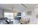 Open concept living and dining room with a modern ceiling fan, tv, and balcony access at 14501 Grove Resort Ave # 2440, Winter Garden, FL 34787