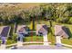 Aerial view of a beautifully landscaped property featuring a spacious backyard, firepit, and surrounding neighborhood at 16379 Blooming Cherry Dr, Groveland, FL 34736