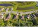 Aerial view of a neighborhood with homes nestled amongst verdant trees and serene ponds, offering a tranquil setting at 16379 Blooming Cherry Dr, Groveland, FL 34736