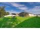 Spacious backyard featuring a large lawn, a screened patio, and a swing at 16379 Blooming Cherry Dr, Groveland, FL 34736