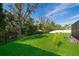 Expansive backyard featuring lush green grass, a charming swing, and beautiful mature trees offering ample shade at 16379 Blooming Cherry Dr, Groveland, FL 34736