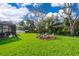 Well-maintained backyard featuring a cozy fire pit area and lush green grass, perfect for outdoor gatherings at 16379 Blooming Cherry Dr, Groveland, FL 34736