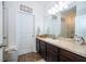 Bathroom with wooden cabinets and a white sink and an above-toilet rack at 16379 Blooming Cherry Dr, Groveland, FL 34736