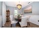 Elegant dining room with modern chandelier, stylish decor, wainscoting and seating for four in this neutral room at 16379 Blooming Cherry Dr, Groveland, FL 34736