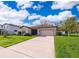 Charming single-story home with a well-manicured lawn, neutral tones, and an inviting front entrance at 16379 Blooming Cherry Dr, Groveland, FL 34736