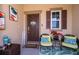 Inviting front porch with seating area, decorative welcome sign, and stylish decor, offering a cozy and welcoming entrance at 16379 Blooming Cherry Dr, Groveland, FL 34736