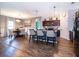 Open-concept kitchen with granite island, dark cabinetry, modern appliances, and pendant lighting adjacent to dining space at 16379 Blooming Cherry Dr, Groveland, FL 34736