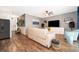 Open living room with dark flooring, neutral decor, a ceiling fan, and a view into the kitchen area at 16379 Blooming Cherry Dr, Groveland, FL 34736
