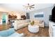 Open living room with an adjacent kitchen area, neutral color palette, and modern furnishings with dark wood floors at 16379 Blooming Cherry Dr, Groveland, FL 34736