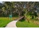 Scenic view of a paved pathway and wooden bridge surrounded by lush greenery and mature trees at 16379 Blooming Cherry Dr, Groveland, FL 34736