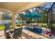 Outdoor patio features brick floors, a screened enclosure and a dining set with an umbrella at 16379 Blooming Cherry Dr, Groveland, FL 34736