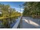 A wooden deck overlooks a tranquil waterway, surrounded by verdant trees and natural beauty at 16379 Blooming Cherry Dr, Groveland, FL 34736