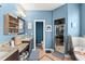 A blue-walled bathroom with dual vanities, dark cabinets, a standalone tub, and a glass-enclosed shower at 17523 Doris St, Montverde, FL 34756