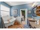 A blue-walled bathroom with a standalone tub, dual vanities, dark cabinets, and a doorway at 17523 Doris St, Montverde, FL 34756