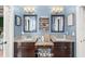 Bathroom featuring dual vanities with dark cabinets, granite countertops and blue colored walls at 17523 Doris St, Montverde, FL 34756