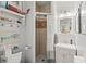 A neutral bathroom with a vanity, commode, and tiled shower with gray and white curtain at 17523 Doris St, Montverde, FL 34756