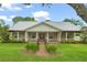 Charming home featuring a metal roof, inviting front porch, and meticulously landscaped yard at 17523 Doris St, Montverde, FL 34756