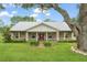 Inviting home featuring a metal roof, welcoming front porch and meticulously maintained front lawn with lush landscaping at 17523 Doris St, Montverde, FL 34756