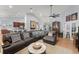 Bright, open-concept living room with tile floors, a sectional couch, and a round marble coffee table at 17523 Doris St, Montverde, FL 34756