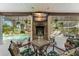 An outdoor patio featuring a television, brick fireplace, and views of the pool and backyard at 17523 Doris St, Montverde, FL 34756
