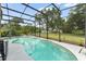 Private backyard pool surrounded by lush landscaping and a screened enclosure at 17523 Doris St, Montverde, FL 34756