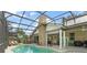 Backyard pool with screened enclosure, cozy outdoor seating and a fireplace at 17523 Doris St, Montverde, FL 34756