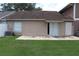 Backyard with grassy lawn, concrete block house with sliding glass doors, and view of roofing structure at 1827 Blaine Ter, Winter Park, FL 32792