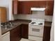Functional kitchen with wood cabinets, a white range, and a double stainless steel sink at 1827 Blaine Ter, Winter Park, FL 32792