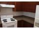 View of the kitchen showcasing wood cabinets, a white range and a refrigerator at 1827 Blaine Ter, Winter Park, FL 32792