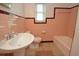 Vintage bathroom featuring pink tile, a pedestal sink, and a classic bathtub at 1975 Waldo St, Orlando, FL 32806
