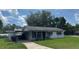 Single-story home with a covered parking area, dark shutters and an American flag at 1975 Waldo St, Orlando, FL 32806