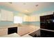 Bright kitchen with white cabinetry, black appliances, and countertop space at 1975 Waldo St, Orlando, FL 32806