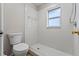 Shower room with an all-tile shower stall, toilet, and window for natural light at 202 Ferryboat Ct, Orlando, FL 32828
