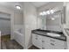 Bright bathroom with a combination tub, white cabinets, granite counters, and large mirror at 202 Ferryboat Ct, Orlando, FL 32828