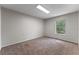 Well lit room with window and neutral colored walls and carpeted floor at 202 Ferryboat Ct, Orlando, FL 32828