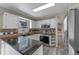 Functional kitchen featuring granite countertops, white cabinetry, stainless steel appliances, and wood-look flooring at 202 Ferryboat Ct, Orlando, FL 32828