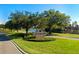 Scenic street view of Crossroads community entrance with lush landscaping and lake at 202 Ferryboat Ct, Orlando, FL 32828