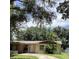 Traditional single-story home featuring a well-manicured front yard with a driveway and mature landscaping at 2023 Messina Ave, Orlando, FL 32811