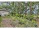 Lush backyard featuring a stone birdbath and a pathway leading through the greenery at 2132 Palm Vista Dr, Apopka, FL 32712