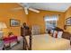 Bedroom featuring bright orange walls, a ceiling fan, and windows providing natural light at 2132 Palm Vista Dr, Apopka, FL 32712